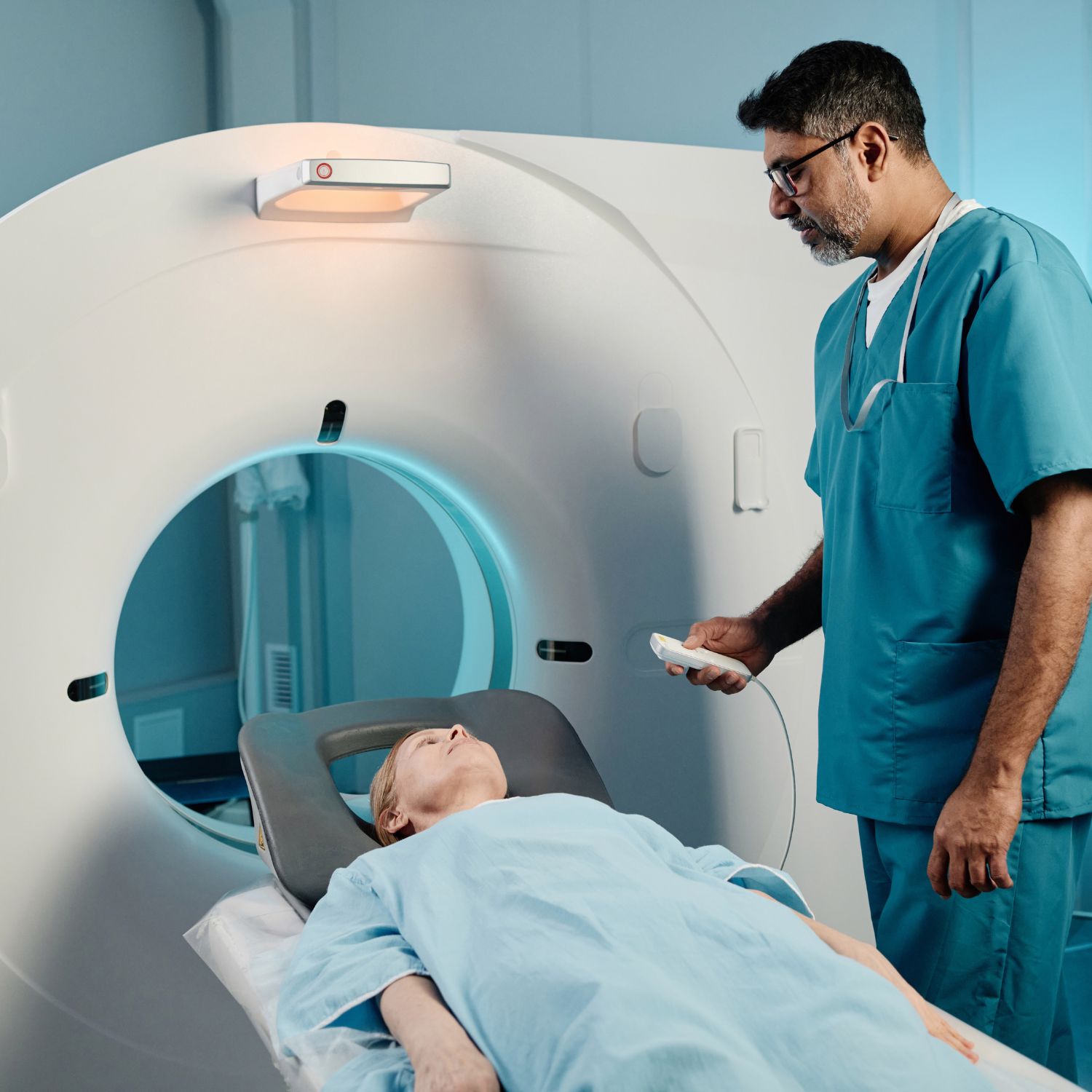 Doctor preparing patient for MRI scan in hospital